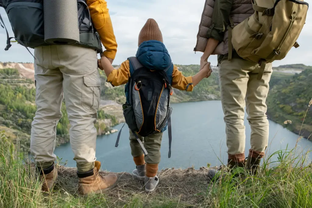 Family vacation: Couple hiking with their child holding hands