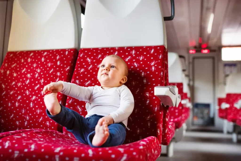 Sustainable family travel - image of a young child on a train seat
